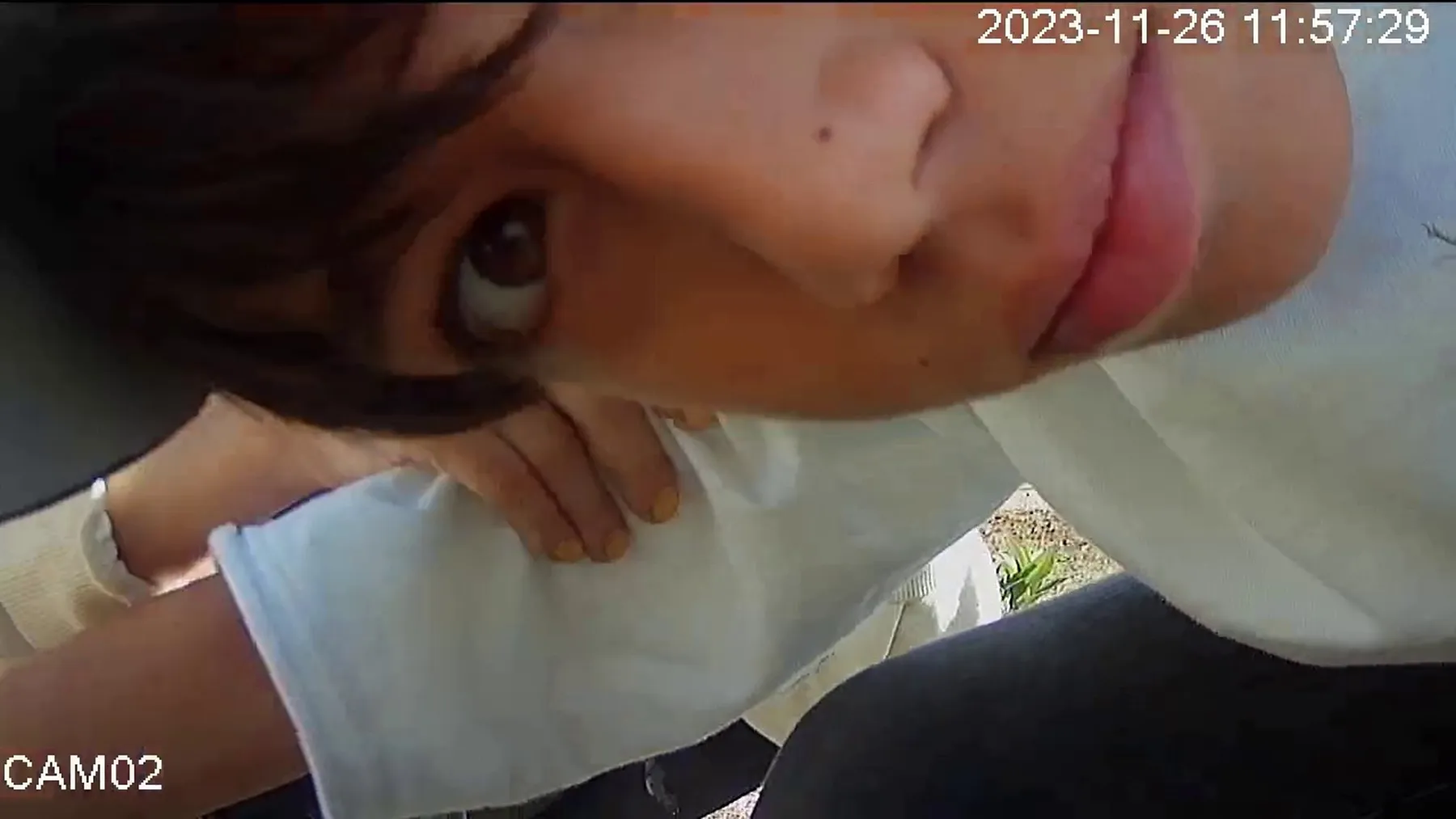 Close CCTV image of a child looking into the camera.