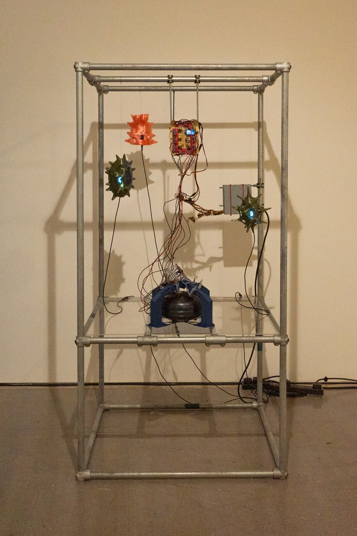Full view of the C4VE DWELLER installation suspended within a metal frame.